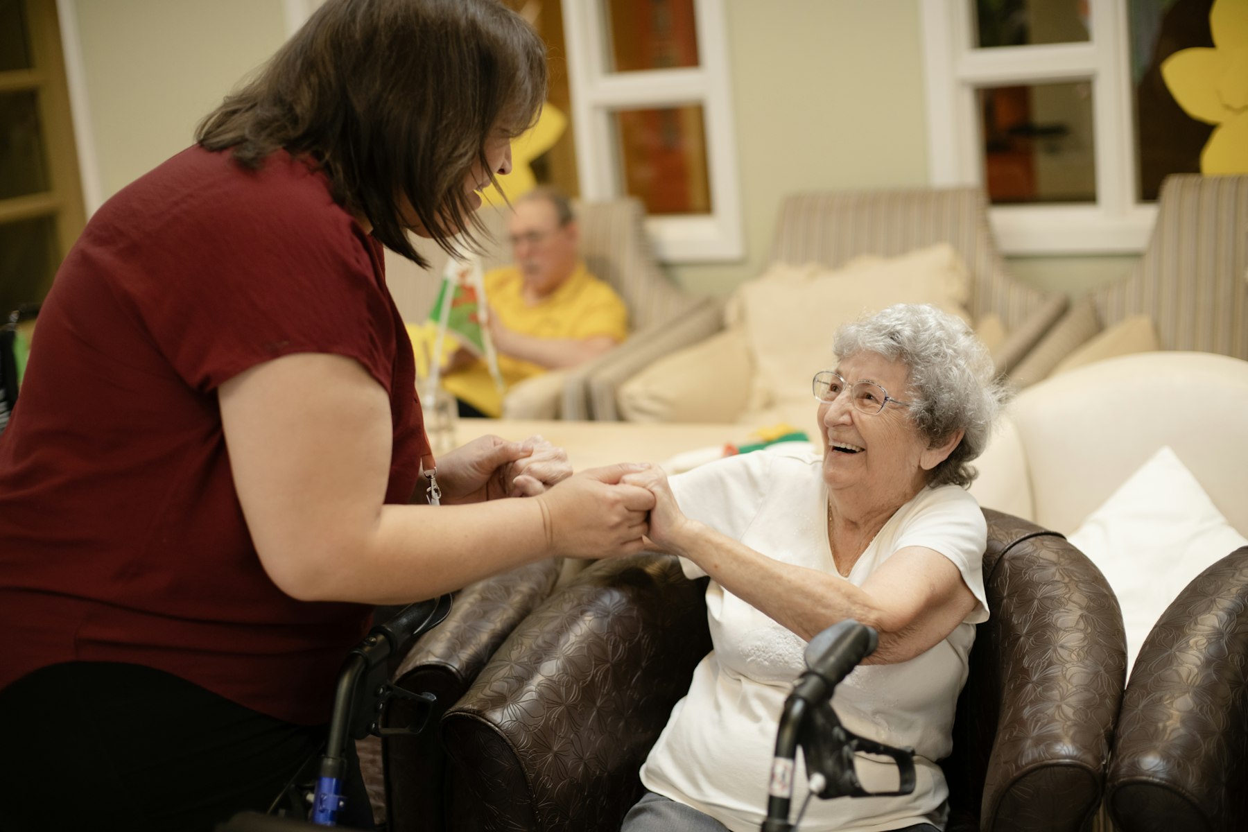 Caregiver helping a resident stand with a walker