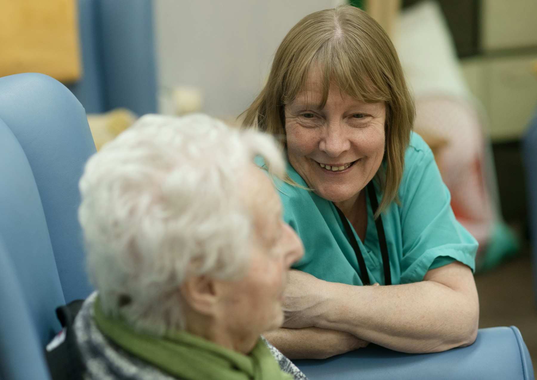 Nurse in scrubs speaking with a resident